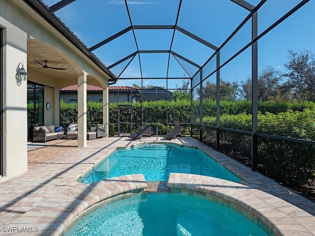 view of swimming pool with ceiling fan, an outdoor hangout area, glass enclosure, and a patio area