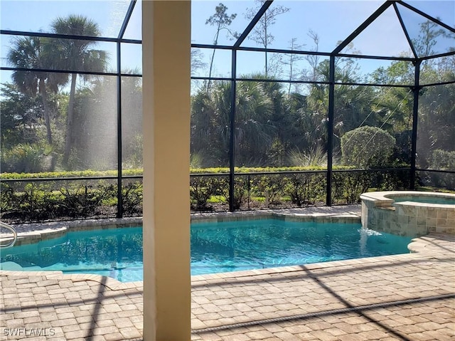 view of pool featuring a patio area, glass enclosure, and an in ground hot tub