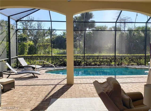 view of pool with a patio and glass enclosure