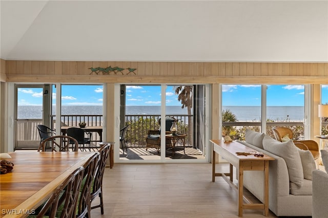 sunroom with a water view and lofted ceiling