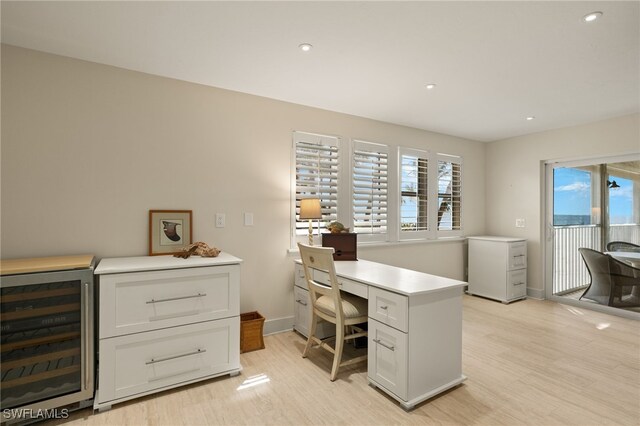 office space with wine cooler and light hardwood / wood-style flooring