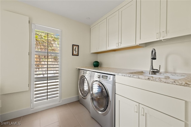 laundry area with cabinets, sink, light tile patterned floors, and washer and clothes dryer