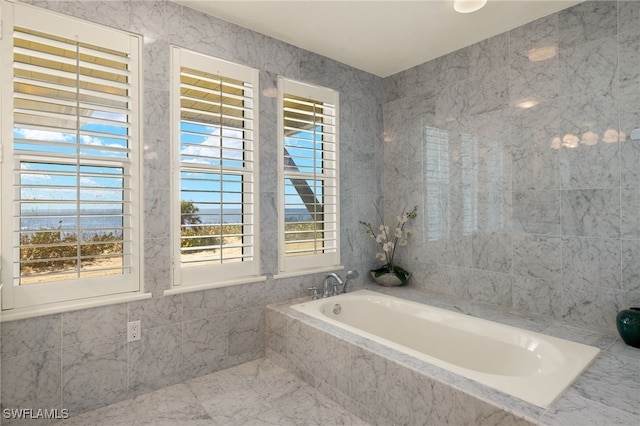 bathroom featuring tile walls and tiled tub