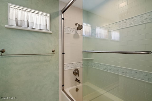 bathroom with combined bath / shower with glass door