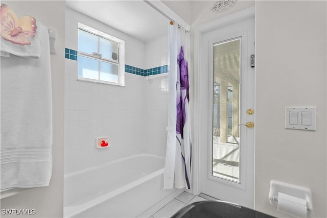 bathroom with shower / tub combo with curtain and tile patterned floors