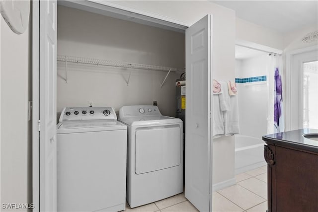 laundry area with washing machine and clothes dryer and light tile patterned flooring