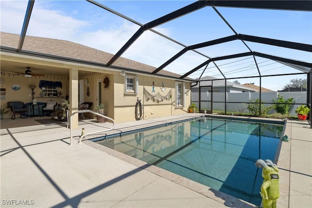 view of swimming pool with ceiling fan, a patio, and glass enclosure