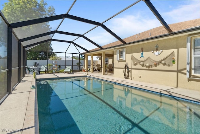 view of swimming pool featuring a patio and glass enclosure