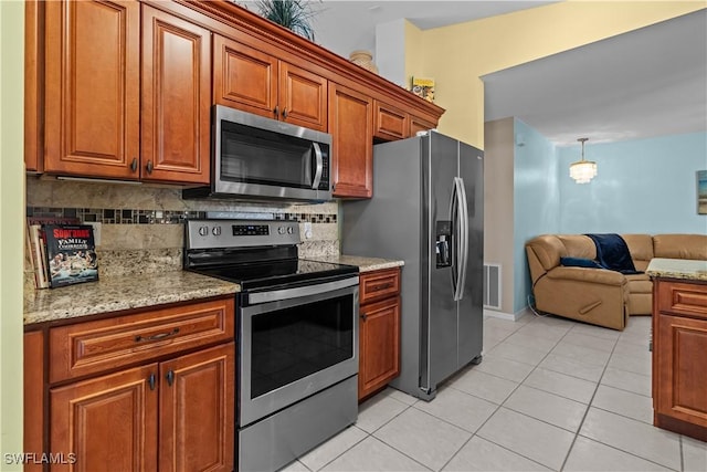 kitchen with light tile patterned floors, hanging light fixtures, stainless steel appliances, light stone countertops, and decorative backsplash