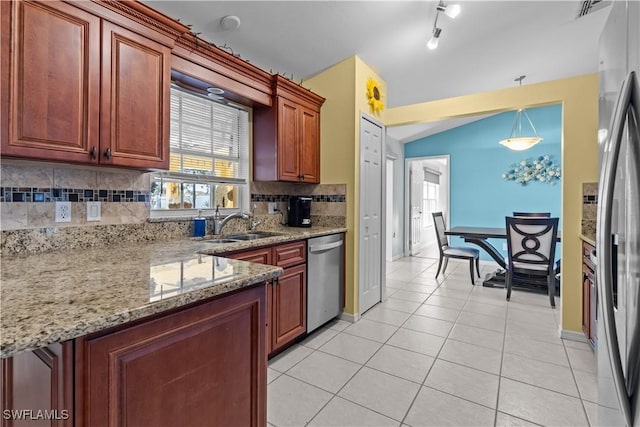 kitchen featuring light tile patterned floors, sink, hanging light fixtures, backsplash, and stainless steel appliances