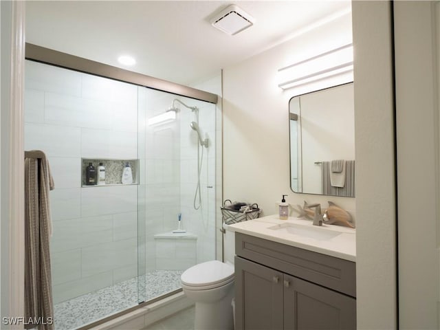 bathroom featuring vanity, toilet, and walk in shower