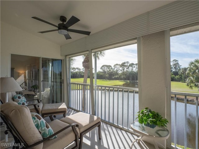 sunroom featuring a water view, ceiling fan, and vaulted ceiling