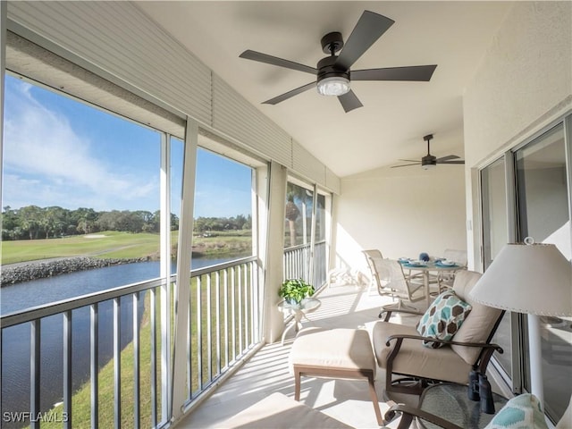 sunroom featuring a water view and lofted ceiling