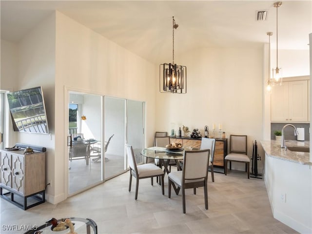 dining space featuring sink, a notable chandelier, and vaulted ceiling