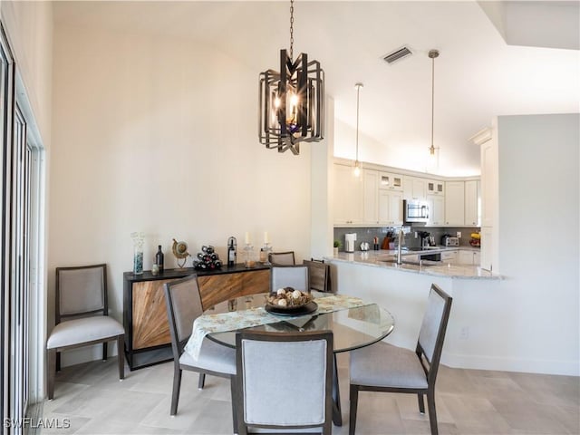 dining room featuring vaulted ceiling, light tile patterned flooring, and an inviting chandelier