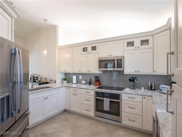 kitchen with stainless steel appliances, sink, hanging light fixtures, and backsplash