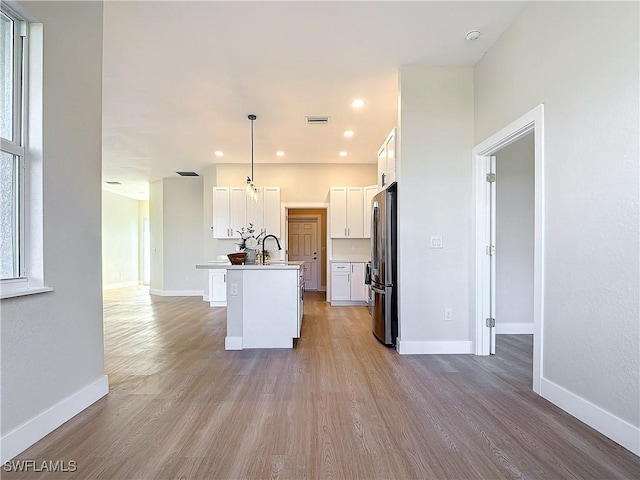 5006 S Peachtree Cir, Labelle, FL 33935 - kitchen featuring freestanding refrigerator, wood finished floors, a kitchen island with sink, and recessed lighting