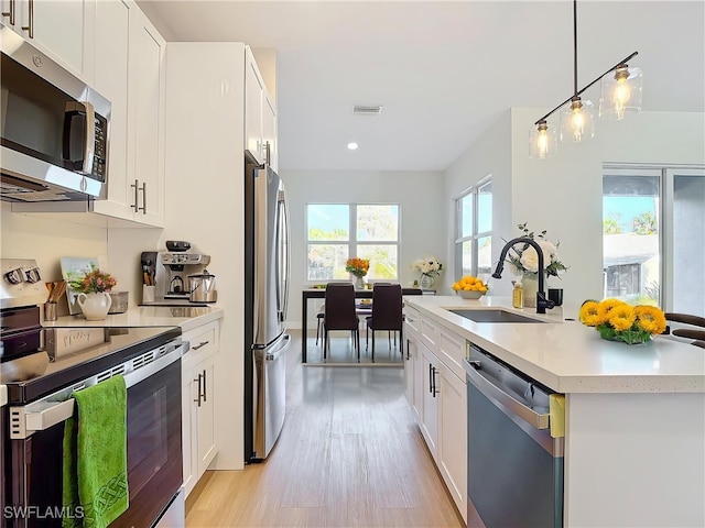 5006 S Peachtree Cir, Labelle, FL 33935 - kitchen featuring appliances with stainless steel finishes, a sink, light wood-style flooring, recessed lighting, and white cabinetry
