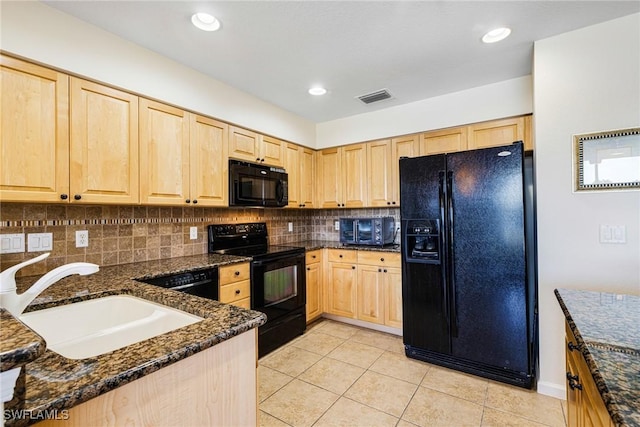 kitchen with sink, dark stone countertops, tasteful backsplash, black appliances, and light tile patterned flooring