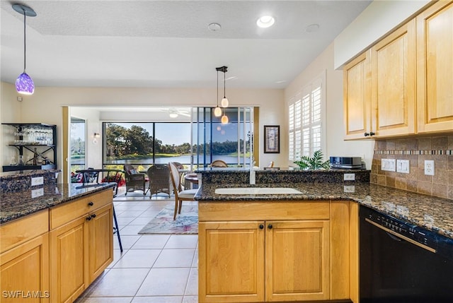 kitchen with dishwasher, dark stone countertops, and pendant lighting