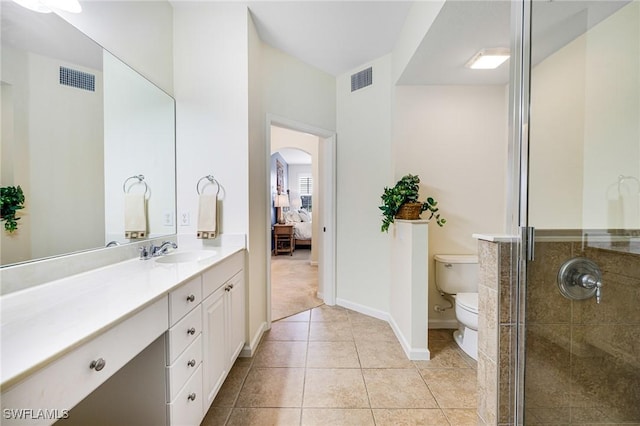 bathroom with vanity, a shower with door, tile patterned floors, and toilet