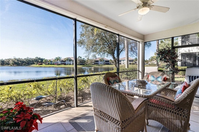 sunroom / solarium featuring a water view and ceiling fan