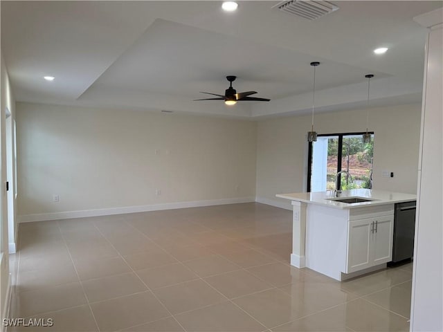 kitchen featuring sink, light tile patterned floors, black dishwasher, white cabinets, and a raised ceiling