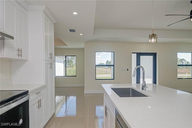 kitchen with recessed lighting, a sink, light tile patterned flooring, and white cabinets