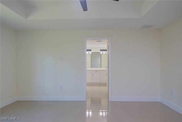 unfurnished room with a ceiling fan, visible vents, baseboards, and light tile patterned floors