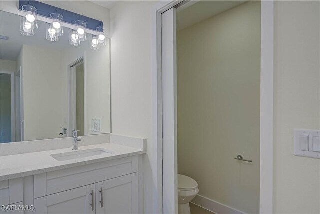 bathroom featuring visible vents, baseboards, vanity, and toilet