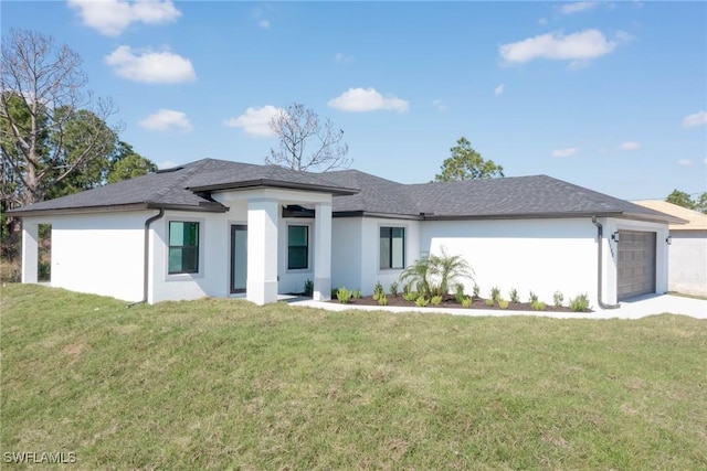 prairie-style home featuring an attached garage, a front lawn, and stucco siding