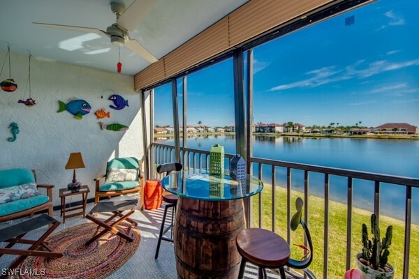 sunroom / solarium with a water view and a ceiling fan