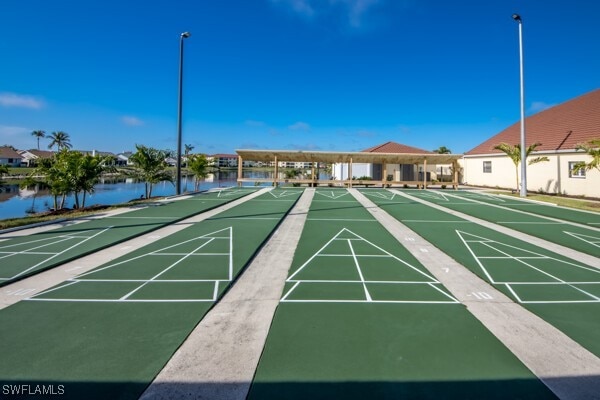 surrounding community with a water view and shuffleboard