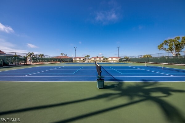 view of tennis court featuring fence