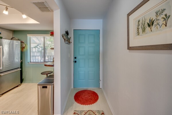 entryway with light wood-style floors, visible vents, and baseboards