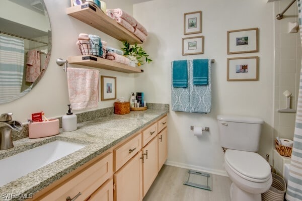 full bathroom with curtained shower, toilet, vanity, wood finished floors, and baseboards