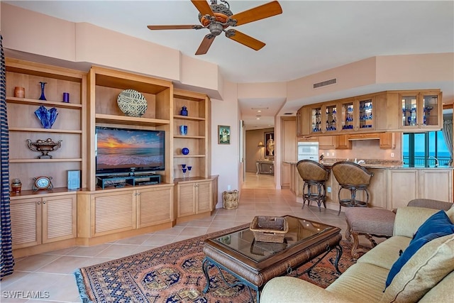 tiled living room featuring ceiling fan and built in features