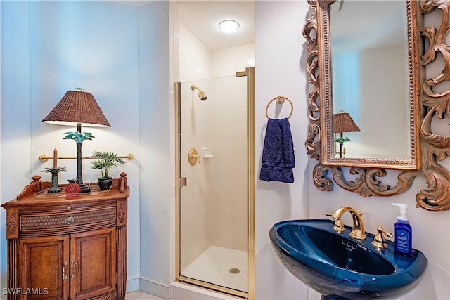 bathroom with a shower with door and sink