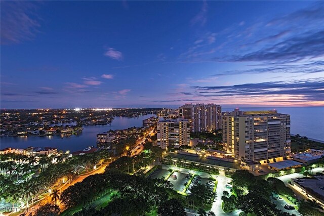 aerial view at dusk featuring a water view