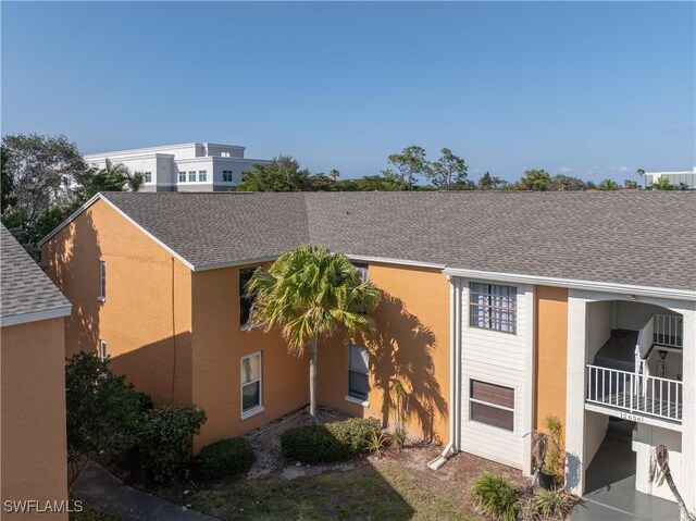 12658 Kenwood Ln Unit D, Fort Myers, FL 33907 - view of property exterior featuring a shingled roof and stucco siding
