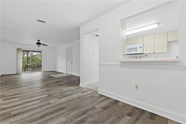 unfurnished living room featuring ceiling fan and hardwood / wood-style floors