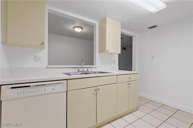 kitchen featuring sink, light tile patterned floors, white dishwasher, and cream cabinetry