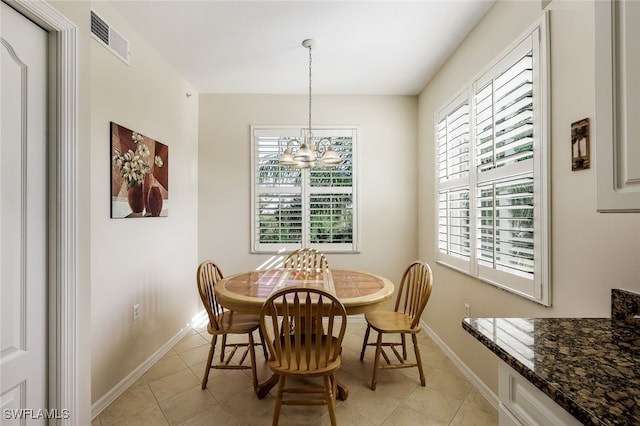 tiled dining area with a notable chandelier and a wealth of natural light