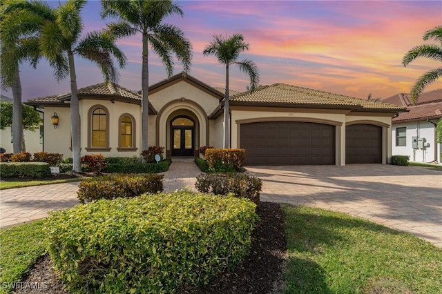 mediterranean / spanish-style home featuring french doors and a garage