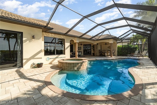 view of swimming pool featuring glass enclosure, a patio, ceiling fan, and an in ground hot tub