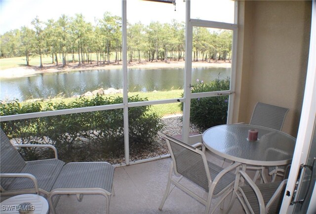 sunroom featuring a water view