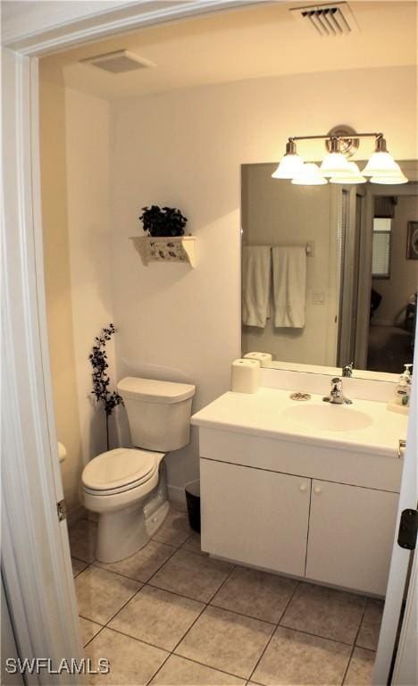 bathroom with tile patterned flooring, vanity, and toilet