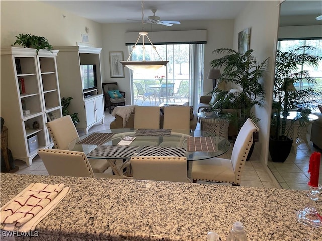 dining space with ceiling fan and light tile patterned flooring