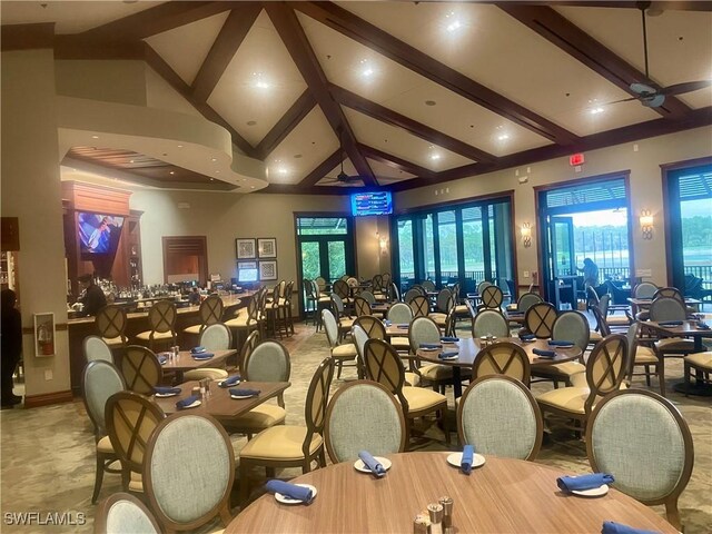 dining area featuring beamed ceiling and a towering ceiling