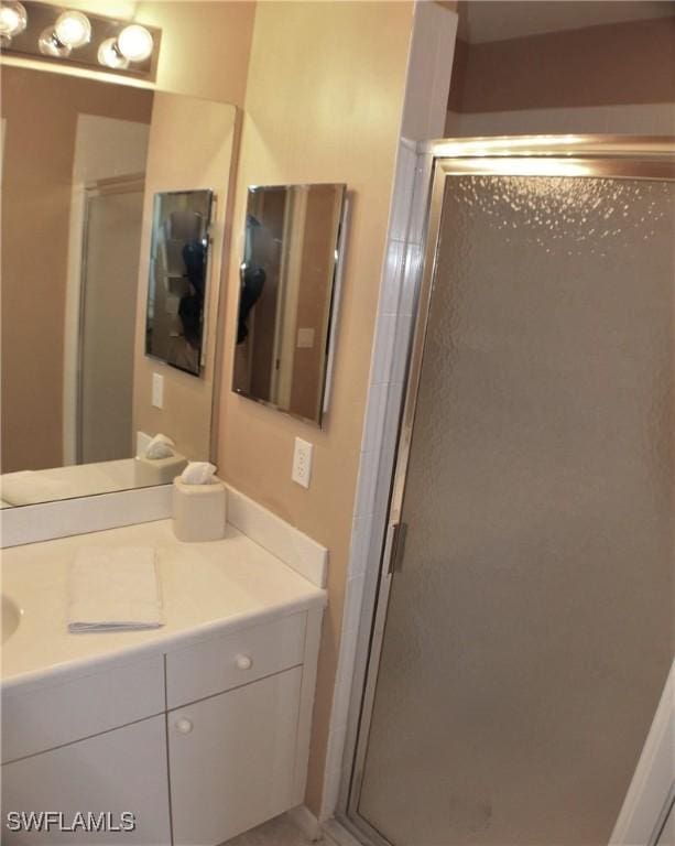 bathroom featuring vanity and a shower with shower door